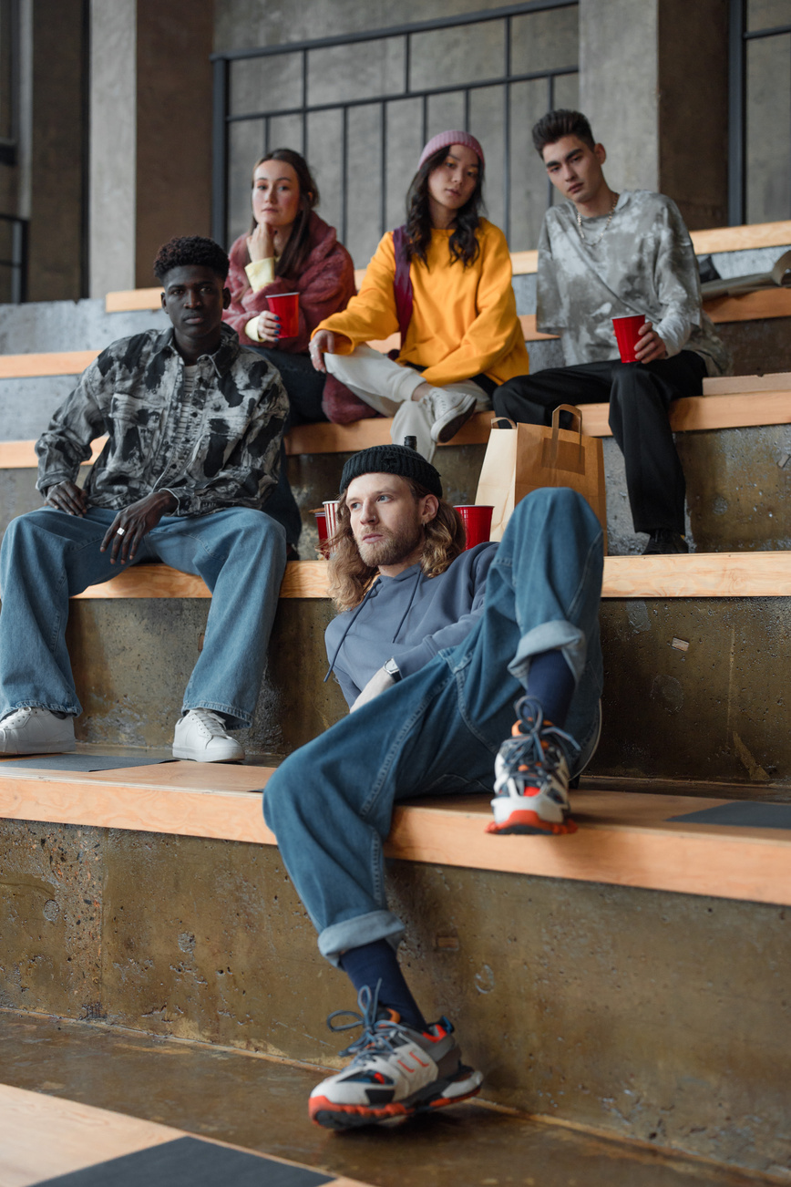 Five Young People in Urban Clothes Sitting on Steps